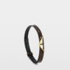 Brown croc-effect embossed leather bracelet with gold wings clasp.